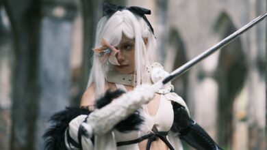 A striking image of a cosplayer in gothic attire wielding a sword in a historical setting in Vietnam.