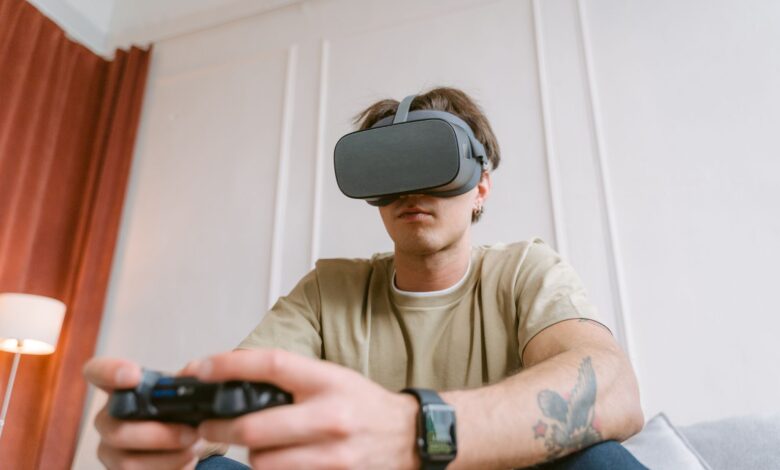 Adult male wearing a VR headset while intensely focused on playing a video game indoors.