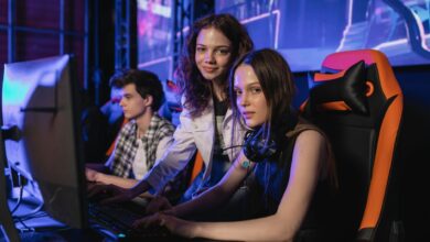 Three teenagers gaming intensely at an esports arena with computers and gaming chairs.