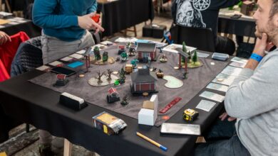 Players engaged in a tabletop miniature game tournament in Zagreb, showcasing strategy and teamwork.