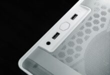 Detailed view of USB and audio ports on a white computer case, showcasing modern technology design.