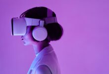 Side view of a woman wearing VR goggles in a purple-lit studio, highlighting modern technology.