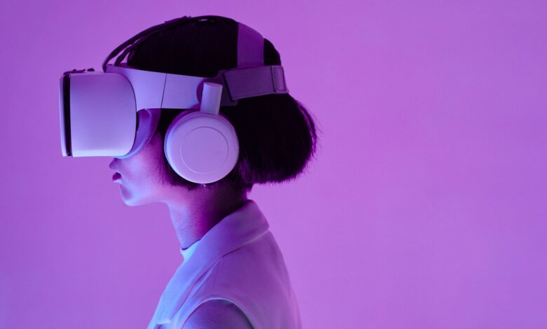 Side view of a woman wearing VR goggles in a purple-lit studio, highlighting modern technology.