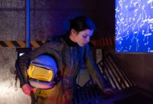 Woman astronaut in futuristic setting examining a digital star chart.