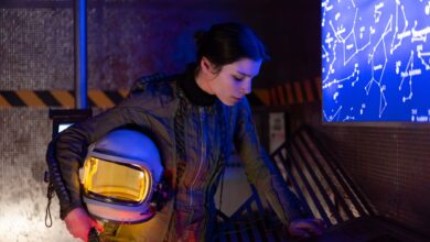 Woman astronaut in futuristic setting examining a digital star chart.