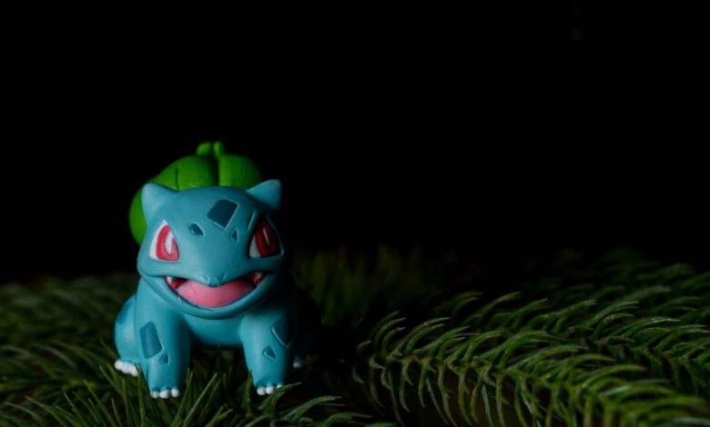 Vibrant Bulbasaur toy placed on pine needles with a dark background.