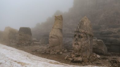 Mysterious ancient stone heads shrouded in fog at Mount Nemrut, Turkey.