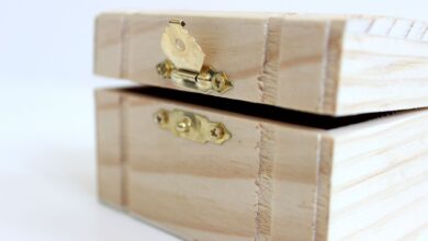 A close-up of an open wooden box with a brass latch, ideal for storage or decoration.