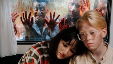 Frightened survivors hide inside while zombies approach the window.
