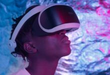 Close-up of a person wearing VR glasses in a neon-lit environment, showcasing technology and user experience.