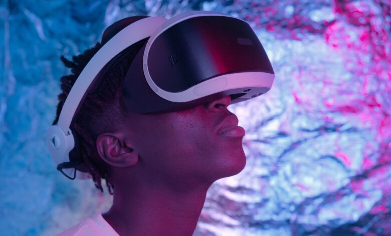 Close-up of a person wearing VR glasses in a neon-lit environment, showcasing technology and user experience.
