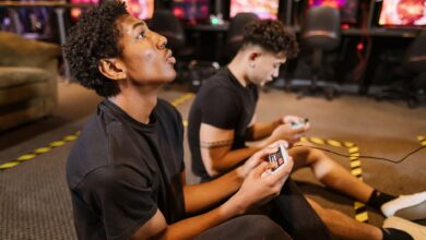 Two teenagers deeply engaged in a video gaming session at an indoor arcade.