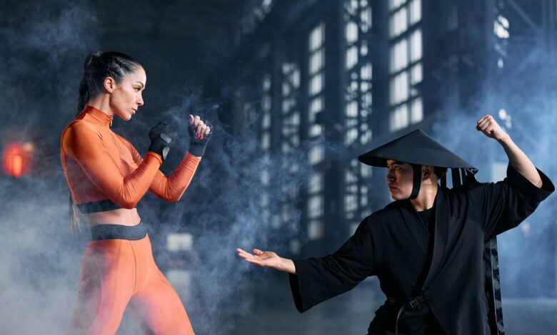Two cosplayers engage in a dynamic martial arts duel amidst dramatic fog, indoors.