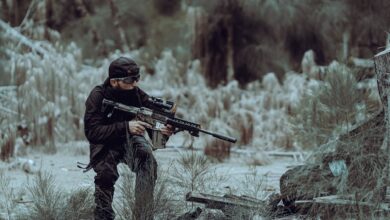 Man in tactical gear practicing outdoor training in Miami's wild forested area, focused and prepared.