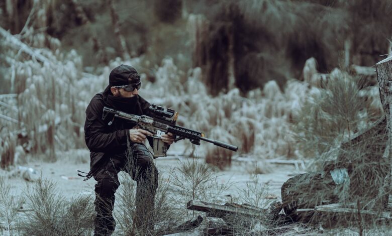 Man in tactical gear practicing outdoor training in Miami's wild forested area, focused and prepared.