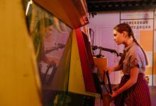 Teenage girl with pigtails playing a vintage arcade game indoors, reflecting vibrant 80s nostalgia.