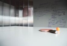 Close-up of ping pong paddle and ball on office table, creative workspace.