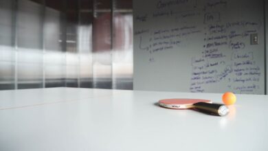 Close-up of ping pong paddle and ball on office table, creative workspace.