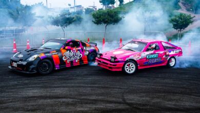 Dynamic scene of colorful drift cars racing on asphalt with smoke and fog in a racing area.
