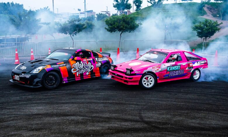 Dynamic scene of colorful drift cars racing on asphalt with smoke and fog in a racing area.