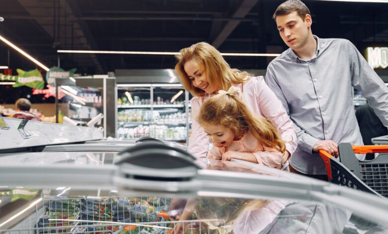 A family enjoying time together while shopping in a supermarket aisle.