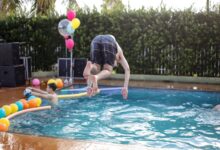 Young adults enjoying a playful and energetic pool party celebration outdoors.