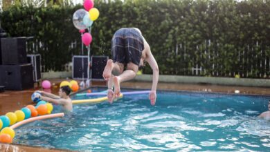 Young adults enjoying a playful and energetic pool party celebration outdoors.