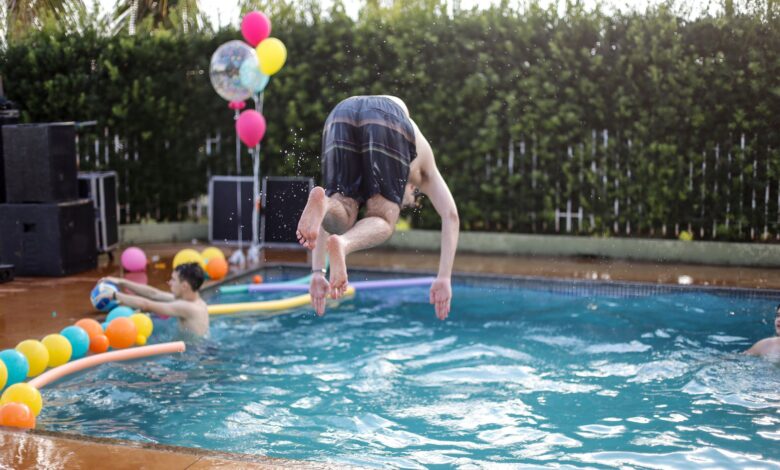 Young adults enjoying a playful and energetic pool party celebration outdoors.