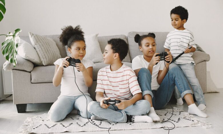 Four children playing video games together in a cozy living room setting.