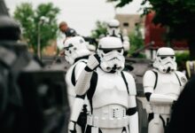 Group of Star Wars stormtrooper cosplayers gathering outdoors during the day.