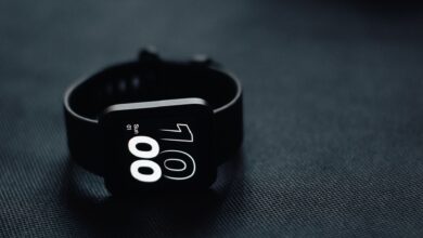Modern smartwatch displaying time on a sleek dark gray surface, perfect for tech enthusiasts.