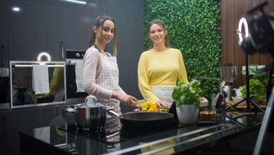 Two women cooking in a sleek kitchen with fresh ingredients and vibrant decor.