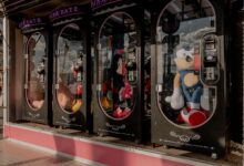 Colorful claw machines filled with plush toys at a fairground arcade, reflecting a fun atmosphere.