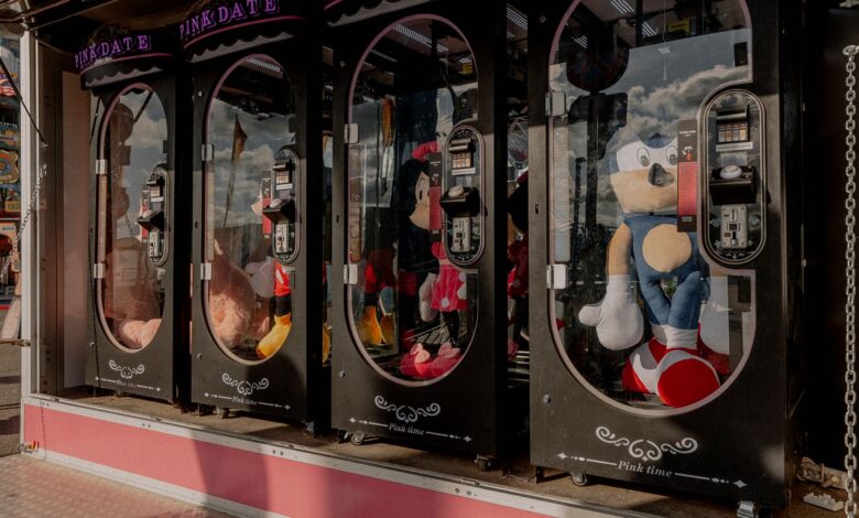 Colorful claw machines filled with plush toys at a fairground arcade, reflecting a fun atmosphere.