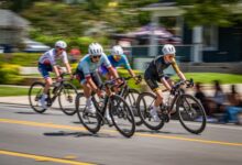 Fast-paced bicycle race with four cyclists competing on a sunny day.
