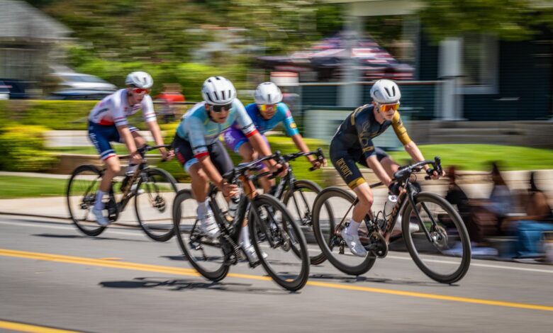 Fast-paced bicycle race with four cyclists competing on a sunny day.