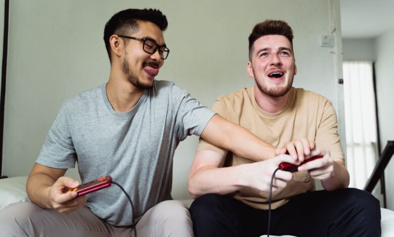 Two friends enjoying a video game session at home, smiling and sharing a fun moment together.