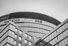 Black and white photo of a modern office building in Gurugram with glass facade and unique architecture.