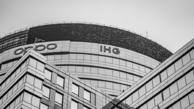 Black and white photo of a modern office building in Gurugram with glass facade and unique architecture.