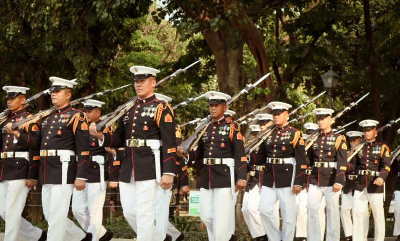 A group of soldiers in formal uniforms marching in a military parade in Manila, Philippines.