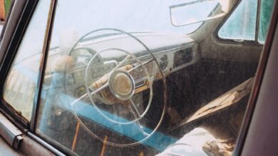 Explore the rustic charm of a vintage car interior with classic steering wheel design.