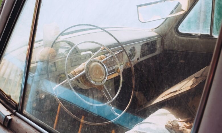 Explore the rustic charm of a vintage car interior with classic steering wheel design.
