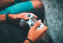 Close-up of hands holding a gaming controller, symbolizing modern gaming culture and leisure.