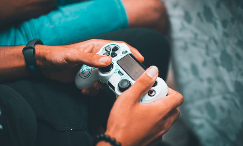 Close-up of hands holding a gaming controller, symbolizing modern gaming culture and leisure.