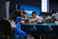 Children enthusiastically engaged in a chess game during a tournament indoors.