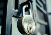Steel padlock securely fastened on a gate, symbolizing security and protection.