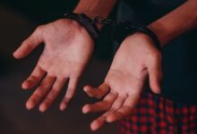 A close-up image showing hands in handcuffs, symbolizing justice and law enforcement.