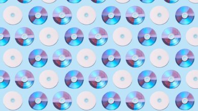 Colorful CDs arranged in a geometric pattern on a light blue background, creating a vibrant visual.
