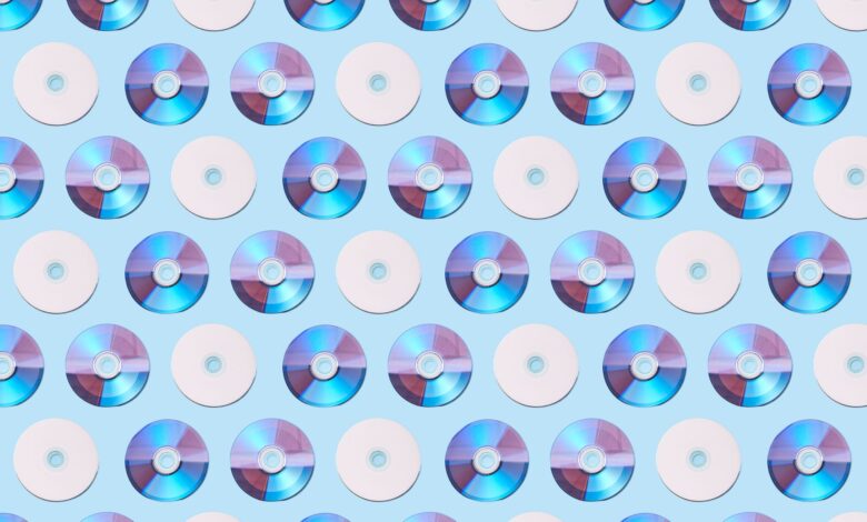 Colorful CDs arranged in a geometric pattern on a light blue background, creating a vibrant visual.
