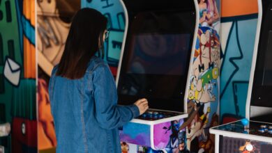 A woman with long hair plays a retro arcade game indoors, enjoying classic gaming fun.